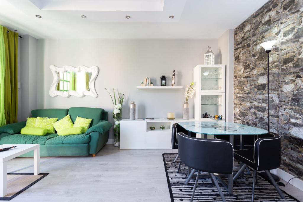 ein Wohnzimmer mit einem grünen Sofa und einem Tisch in der Unterkunft Home2Book Charming Sea Front House in El Escobonal