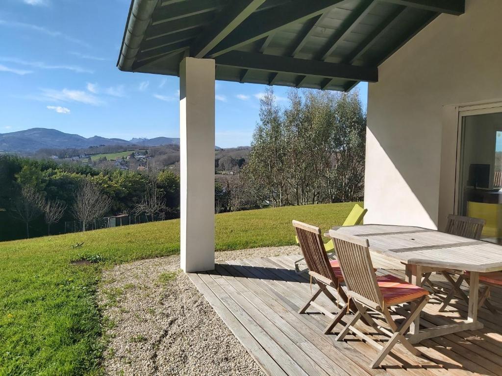 a wooden table and chairs on a deck with a view at Appartement Ascain, 3 pièces, 4 personnes - FR-1-239-504 in Ascain