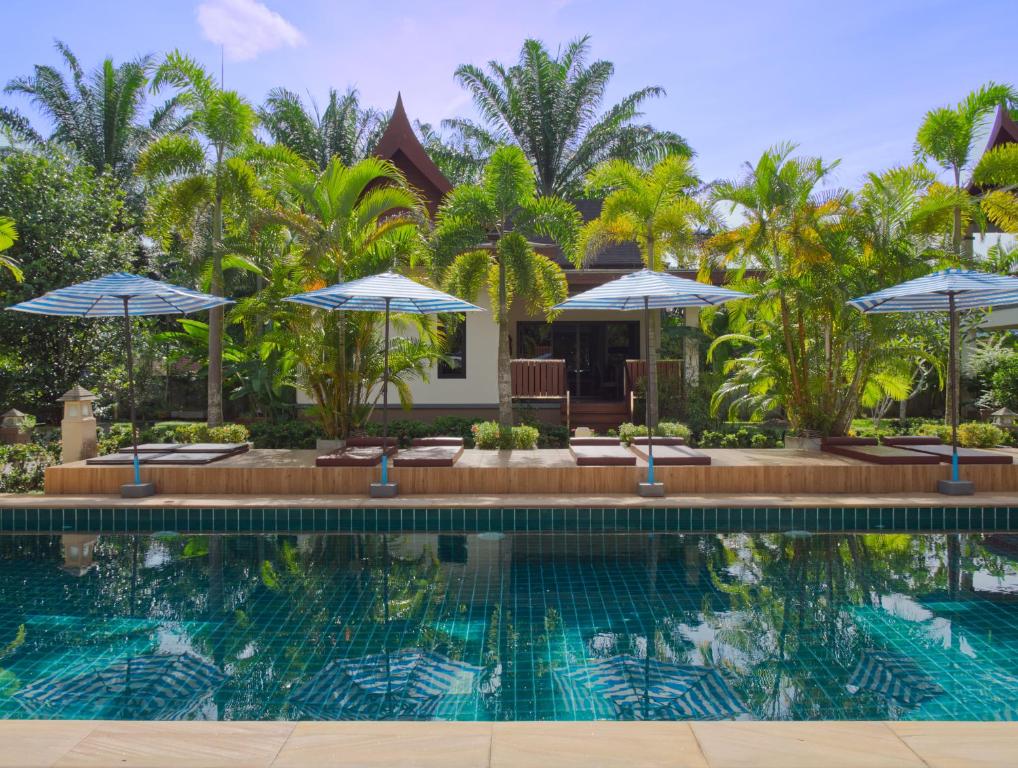 a villa with a swimming pool and umbrellas at Chanapha Residence in Tab Kaek Beach