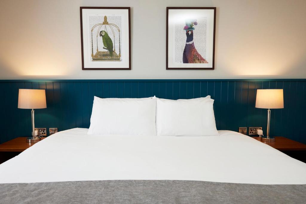 1 dormitorio con 1 cama blanca grande y 2 lámparas en The Caledonian Hotel, en Leven