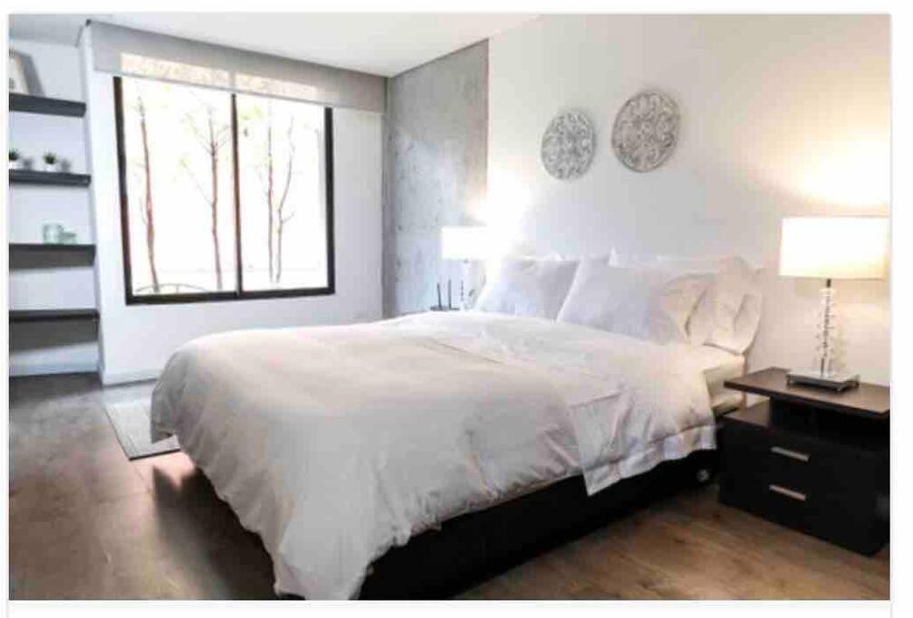 ein Schlafzimmer mit einem großen weißen Bett und einem Fenster in der Unterkunft Acogedor y amplio apartamento perfecta ubicacion! in Bogotá