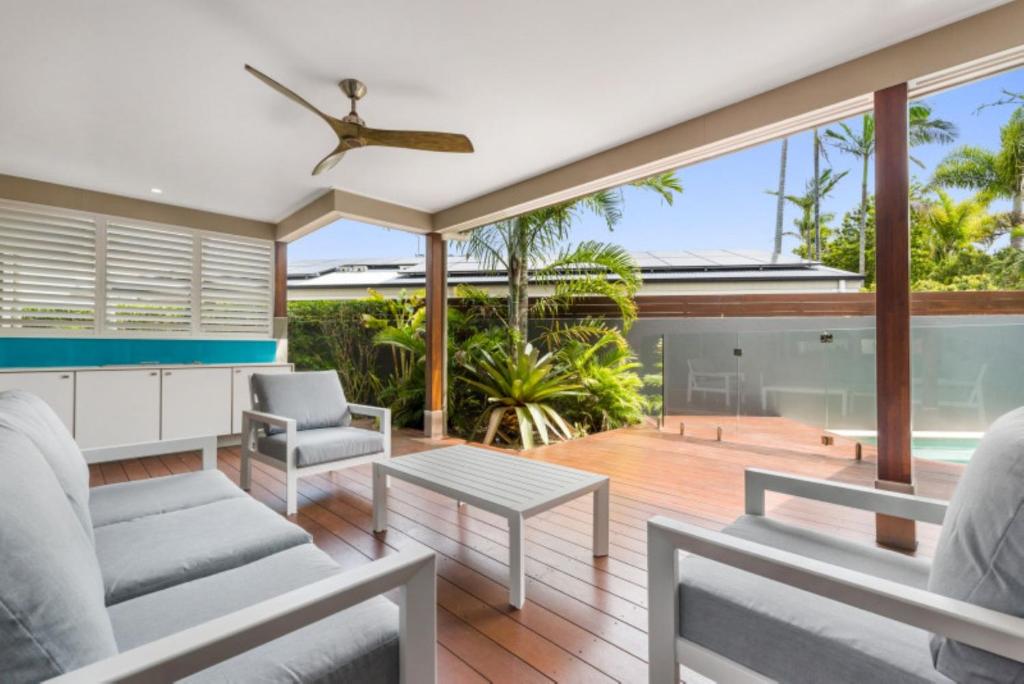 a living room with chairs and a ceiling fan at Key Ct 10 in Noosa Heads