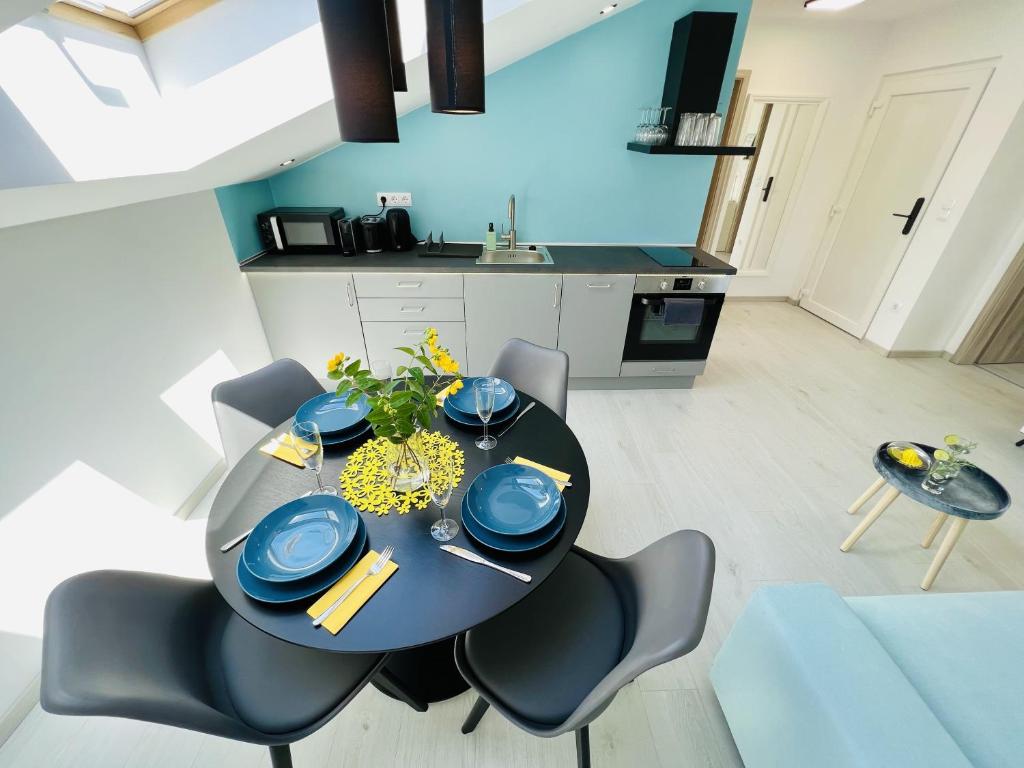 een eettafel en stoelen in een kamer met een keuken bij Villa Szófia Veszprém apartments in Veszprém