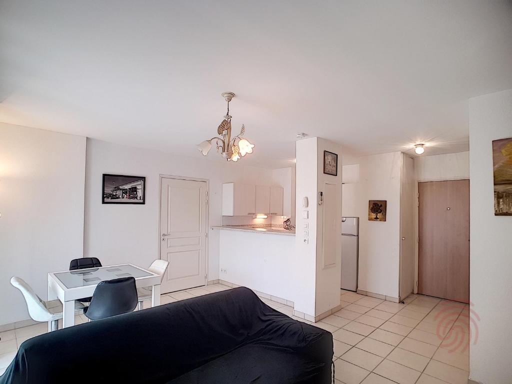 un salon avec un canapé et une table dans l'établissement Appartement F2 avec terrasse, clim, parking privé, proche centre-ville et thermes, animaux acceptés - FR-1-451-135, à Lamalou-les-Bains