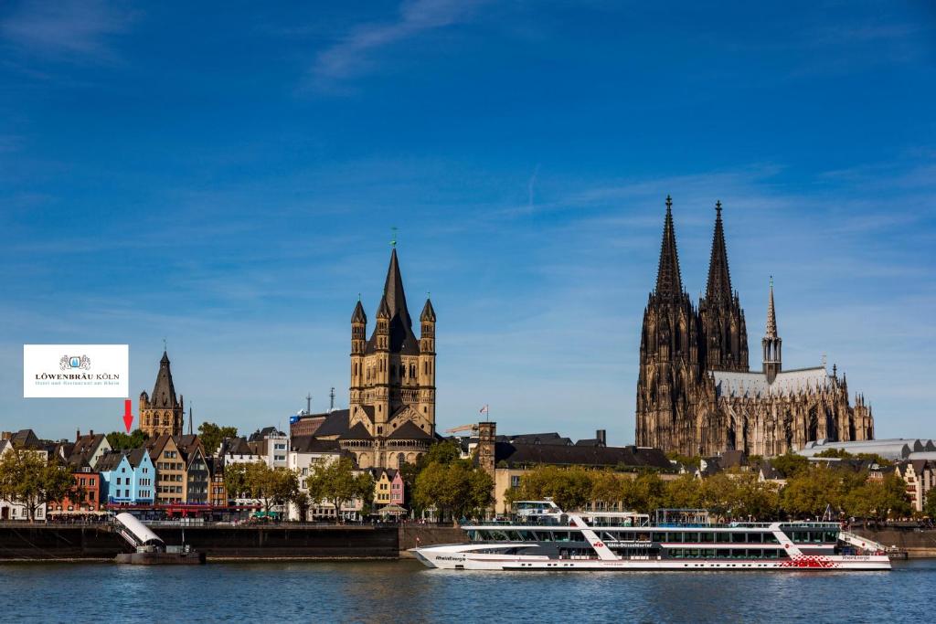 eine Stadt mit einem Fluss und einem Boot im Wasser in der Unterkunft Hotel und Restaurant Löwenbräu Köln in Köln