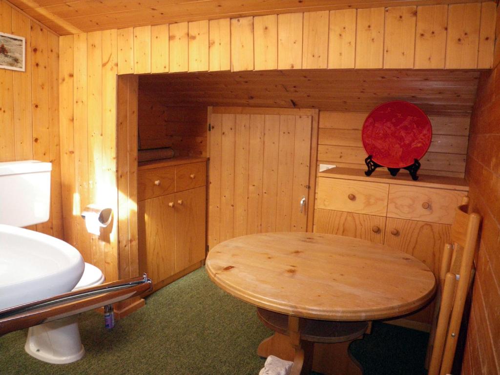 Habitación pequeña de madera con mesa y lavamanos en Carezza Units, Dolomites, en Carezza al Lago