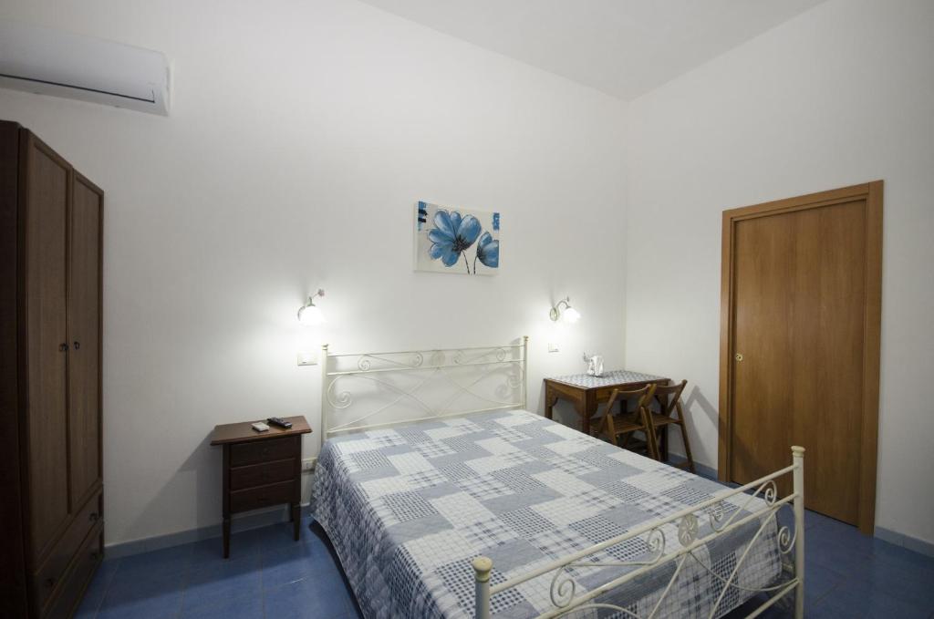 a small bedroom with a bed and a nightstand and a bed sidx sidx sidx at Appartamenti da Clarissa in Macari