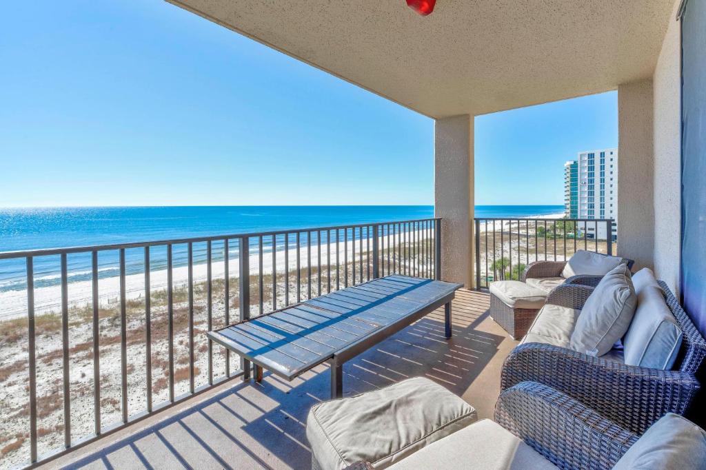 een balkon met een tafel en stoelen en het strand bij Phoenix X 603 in Orange Beach
