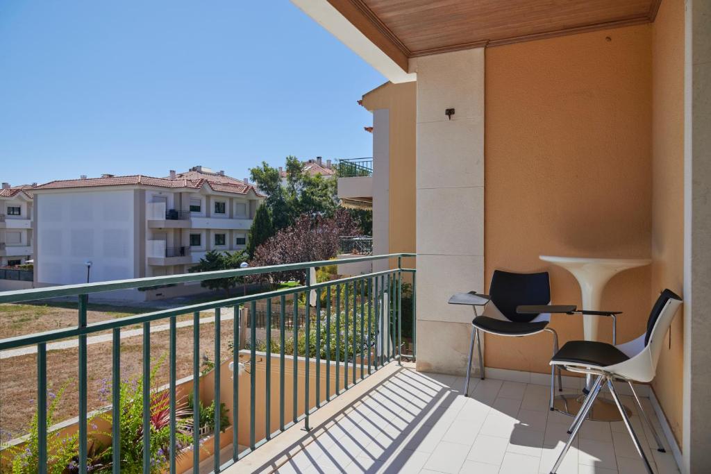 - un balcon avec 2 chaises dans l'établissement Apartamento junto NOVA&PRAIA Carcavelos II, à Carcavelos
