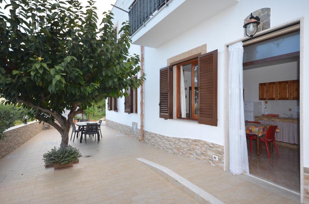 a house with a patio with a tree and a table at Appartamenti da Clarissa in Macari