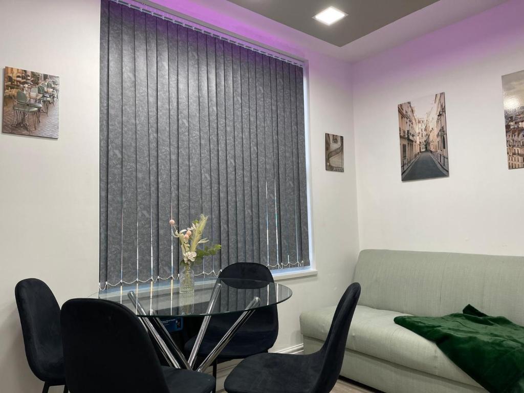 a living room with a glass table in front of a window at Luis apartments in Leeds in Leeds