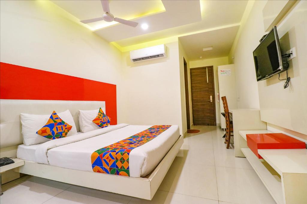 a bedroom with a bed and a television in it at FabHotel Golden Home in Amritsar