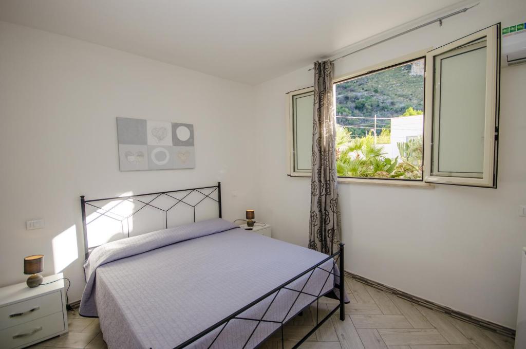 a bedroom with a bed and a window at Appartamenti da Clarissa in Macari