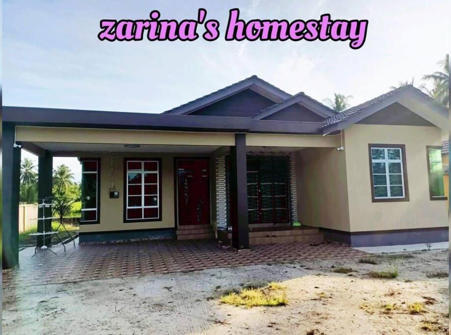 mały dom z czerwonymi drzwiami w obiekcie Zarina's Budget Homestay w mieście Tumpat