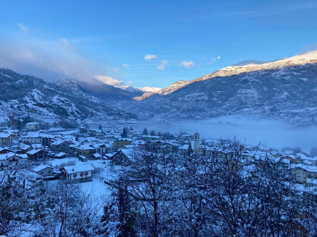 une ville recouverte de neige avec un lac et des montagnes dans l'établissement La maison de Linanna, à Aymavilles
