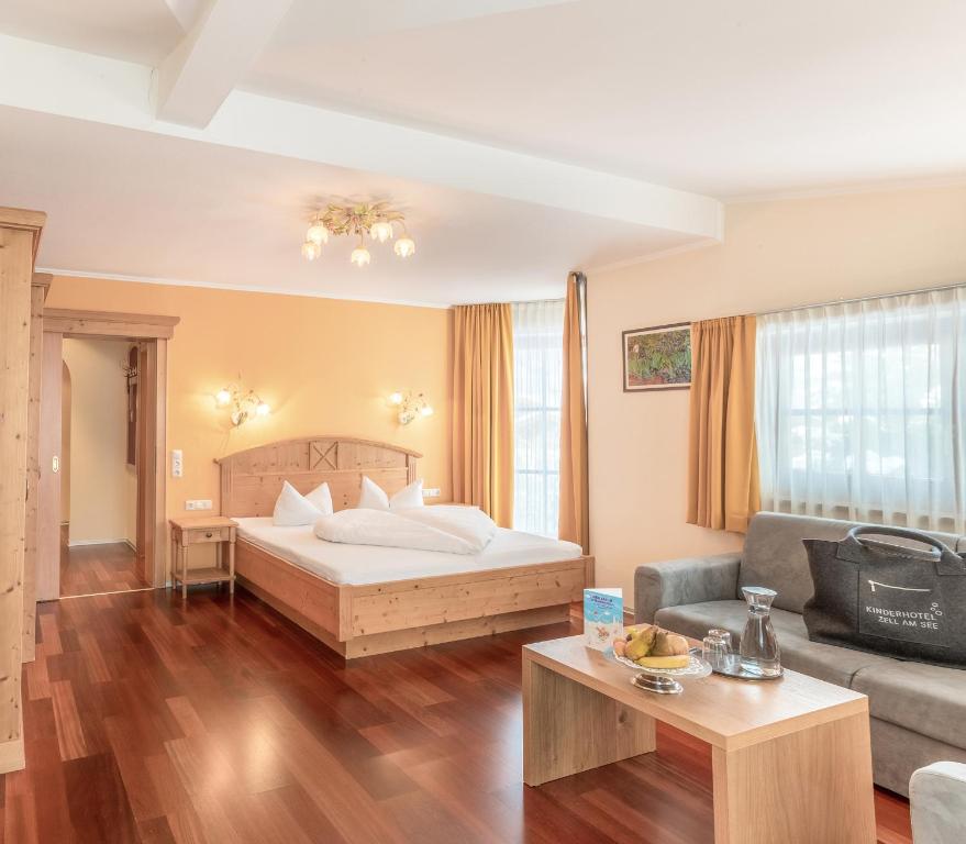 a hotel room with a bed and a couch at HAIDVOGL MAVIDA Zell am See in Zell am See