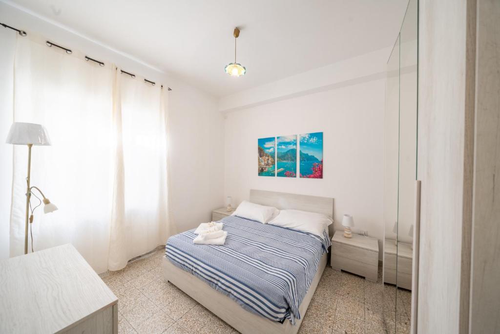 a white bedroom with a bed and a window at DACHI HOLIDAY HOUSE in Amalfi