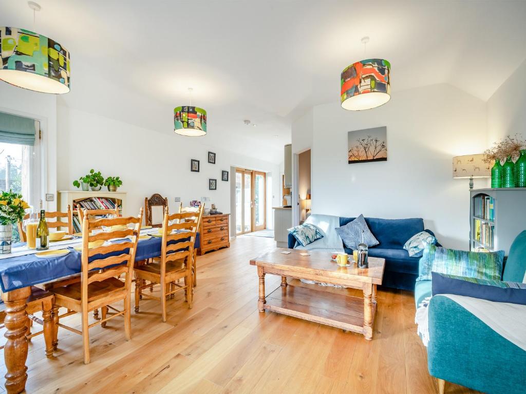 Larks Nest في Wortham: غرفة معيشة مع أريكة زرقاء وطاولة