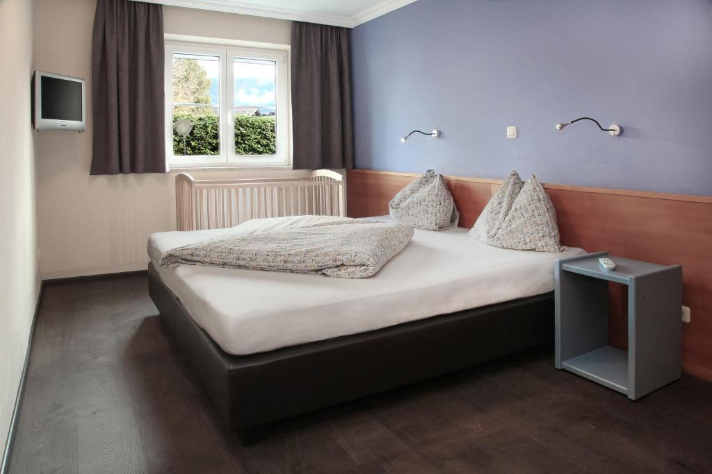 a bedroom with a bed and a window at HAIDVOGL MAVIDA Zell am See in Zell am See