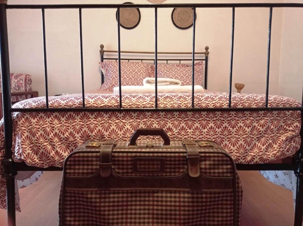 walizka na podłodze obok łóżka w obiekcie Stunning House in Mirandela ideal for 10 people w mieście Mirandela
