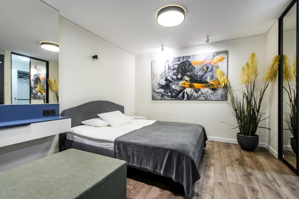 a room with two beds and a tv and a painting at Botanical Garden loft in Kaunas