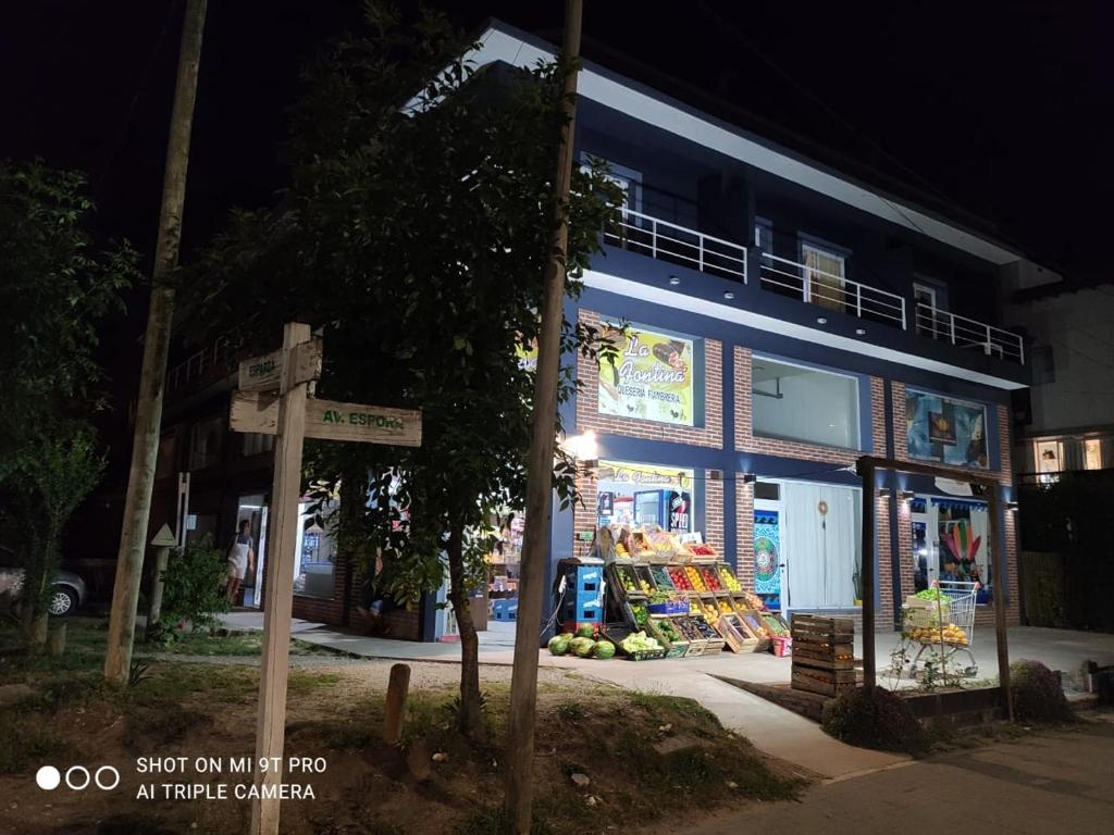 a street sign in front of a store at night at Hospedaje Familia Puma in Valeria del Mar