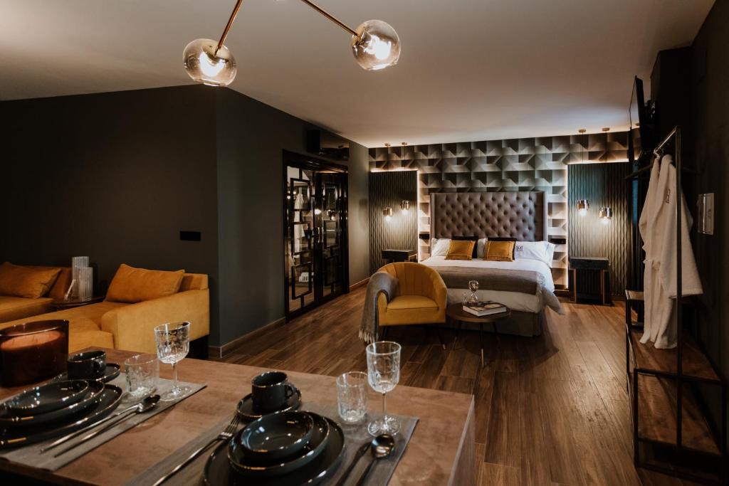 Una habitación de hotel con una cama y una mesa con platos. en Apartamentos Boutique Heritage, en San Martín de Trevejo