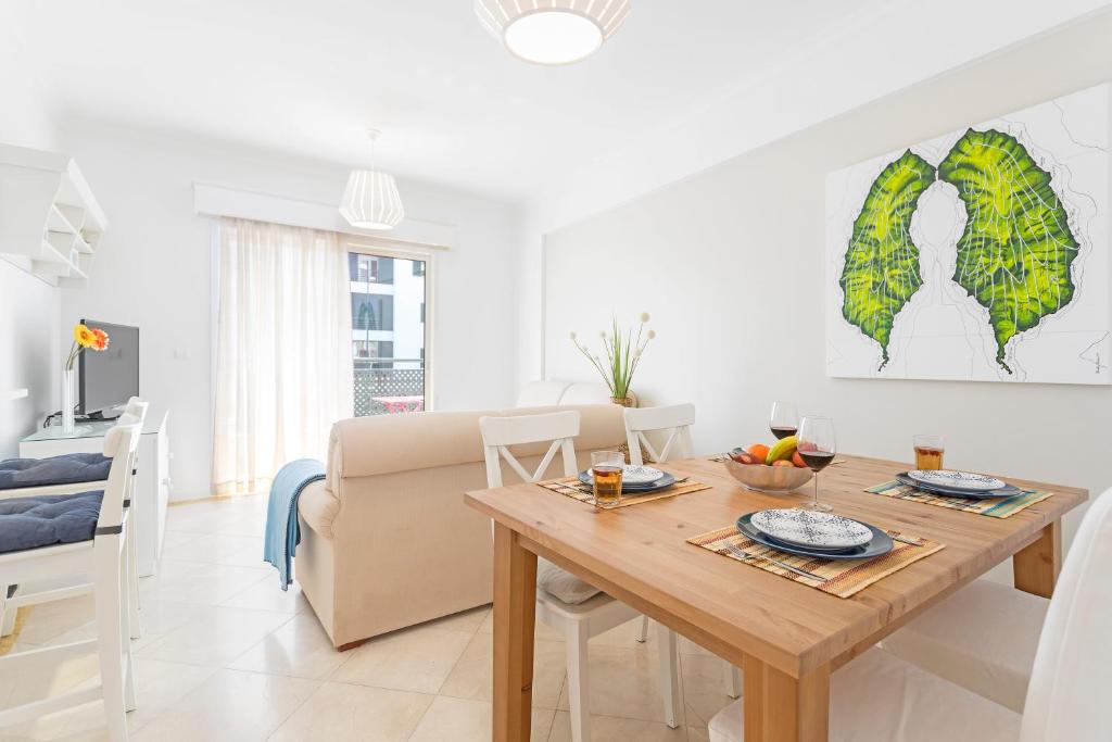 a kitchen and living room with a table and a couch at Ajuda II by An Island Apart in Funchal