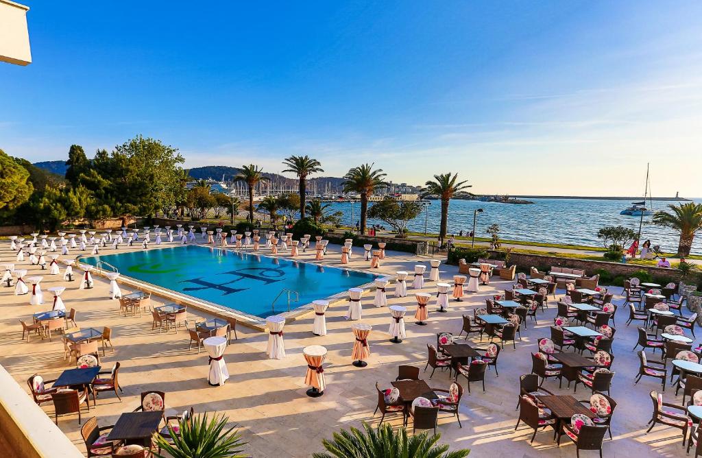 a group of people sitting in chairs around a pool at Hotel Princess in Bar