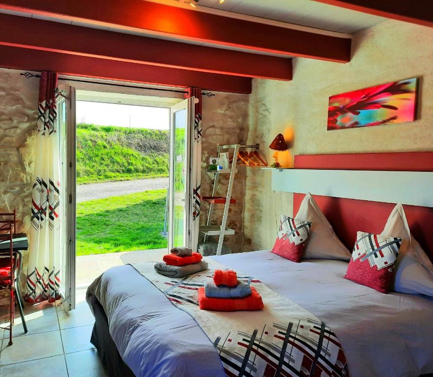 a bedroom with a large bed in a room with a window at L'Echappée Trémoussante in Saint-Barthélemy-de-Vals