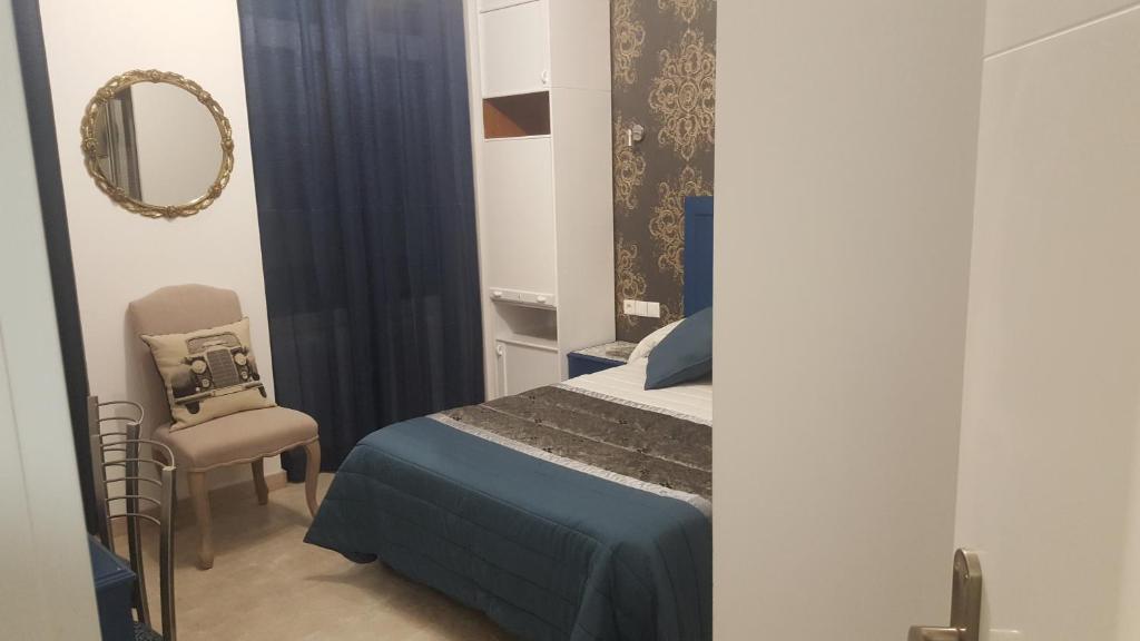 a bedroom with a bed and a mirror and a chair at hospedaje barahona21 in León