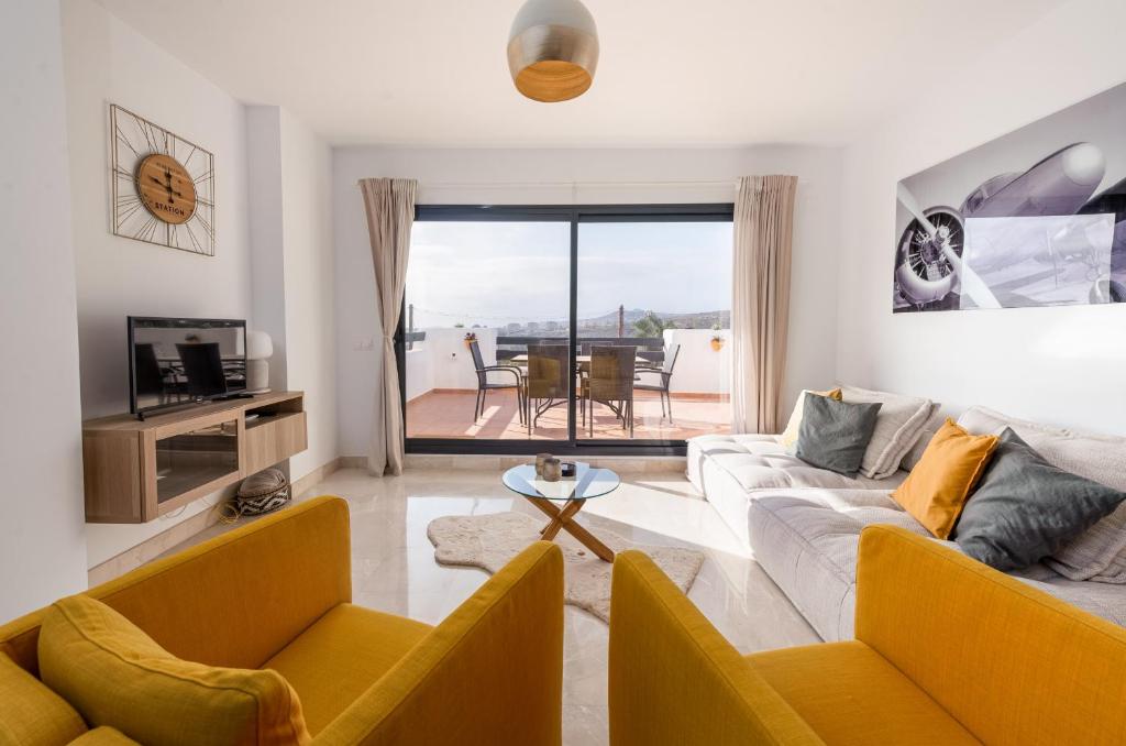 salon z 2 kanapami i stołem w obiekcie Lotus 2401 - Beautiful apartment with pool & sea view w mieście Casares