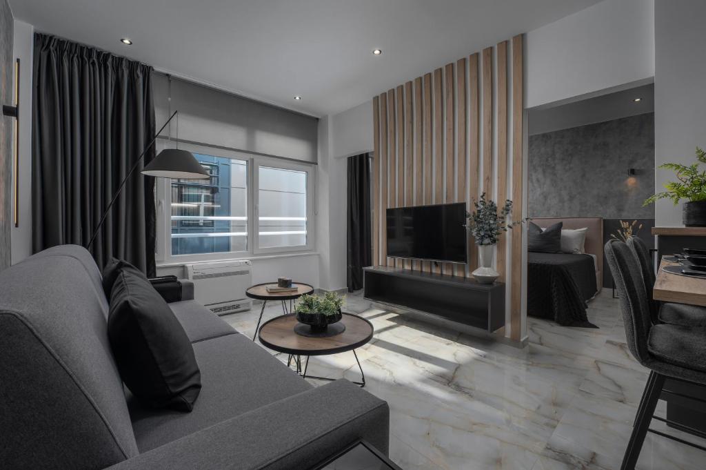 Nomades Suites في سلانيك: غرفة معيشة مع أريكة وتلفزيون