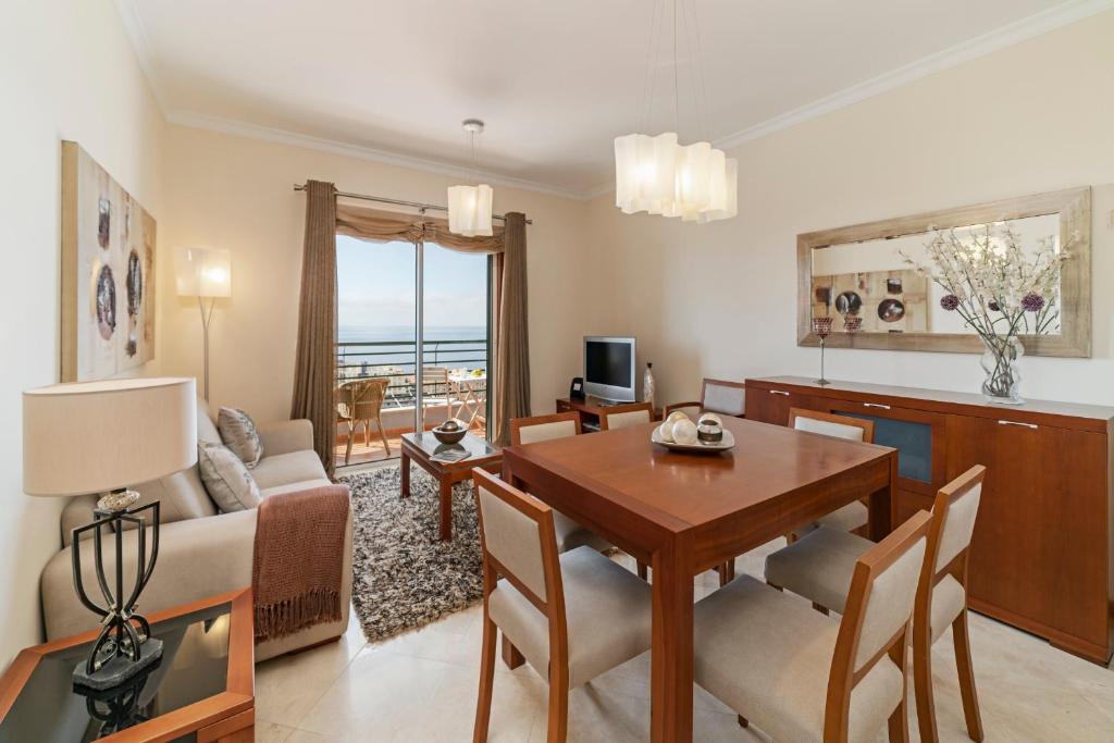 uma sala de estar com uma mesa e uma sala de jantar em Ajuda III by An Island Apart no Funchal