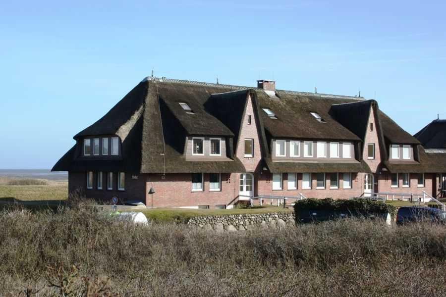 ein großes Backsteinhaus mit schwarzem Dach in der Unterkunft Haus Friedeburg - Gericke in Rantum