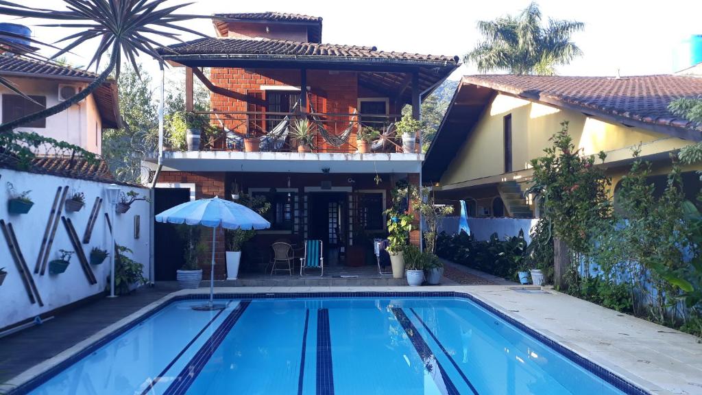 a house with a swimming pool in front of a house at Casa praia Camburi com piscina in Camburi