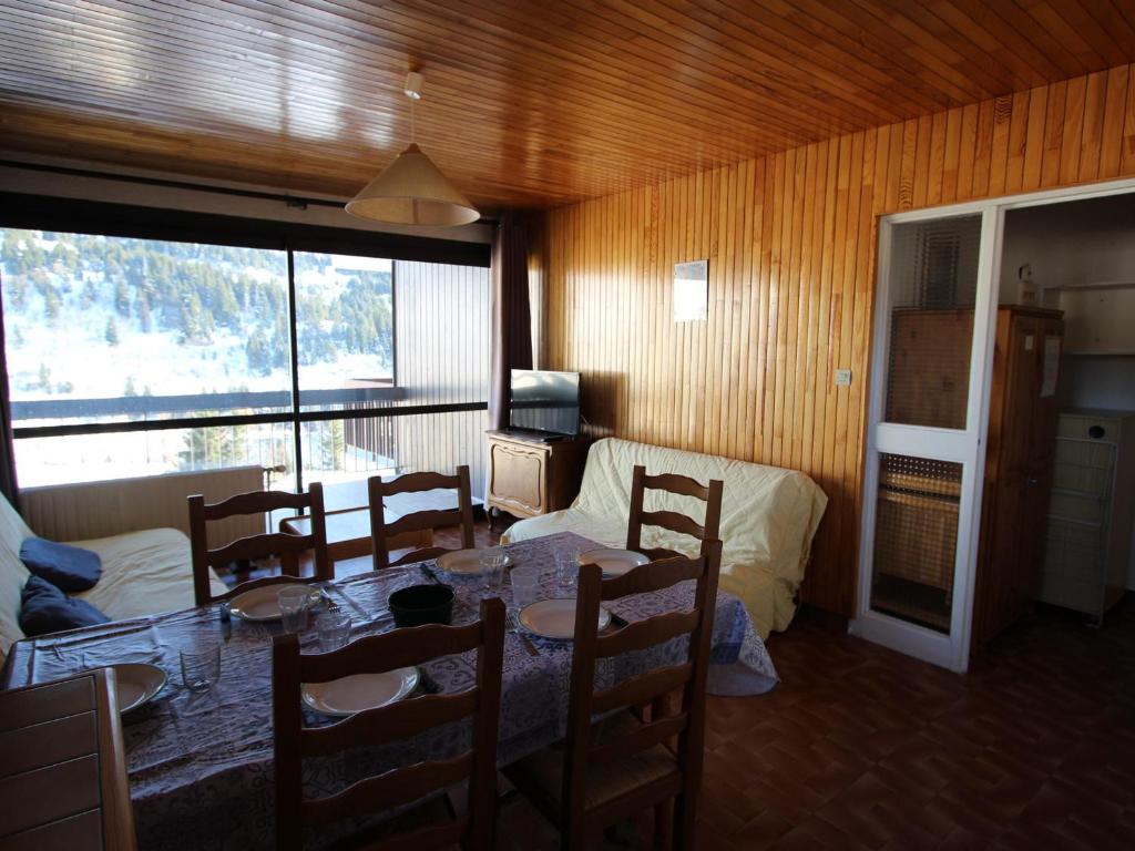een eetkamer met een tafel en stoelen in een kamer bij Appartement Chamrousse, 2 pièces, 6 personnes - FR-1-340-101 in Chamrousse