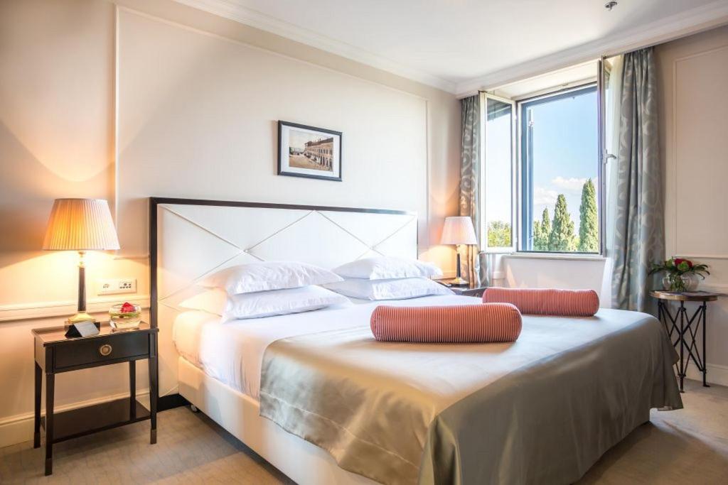 a bedroom with a large bed with a large window at Hotel Park Split in Split