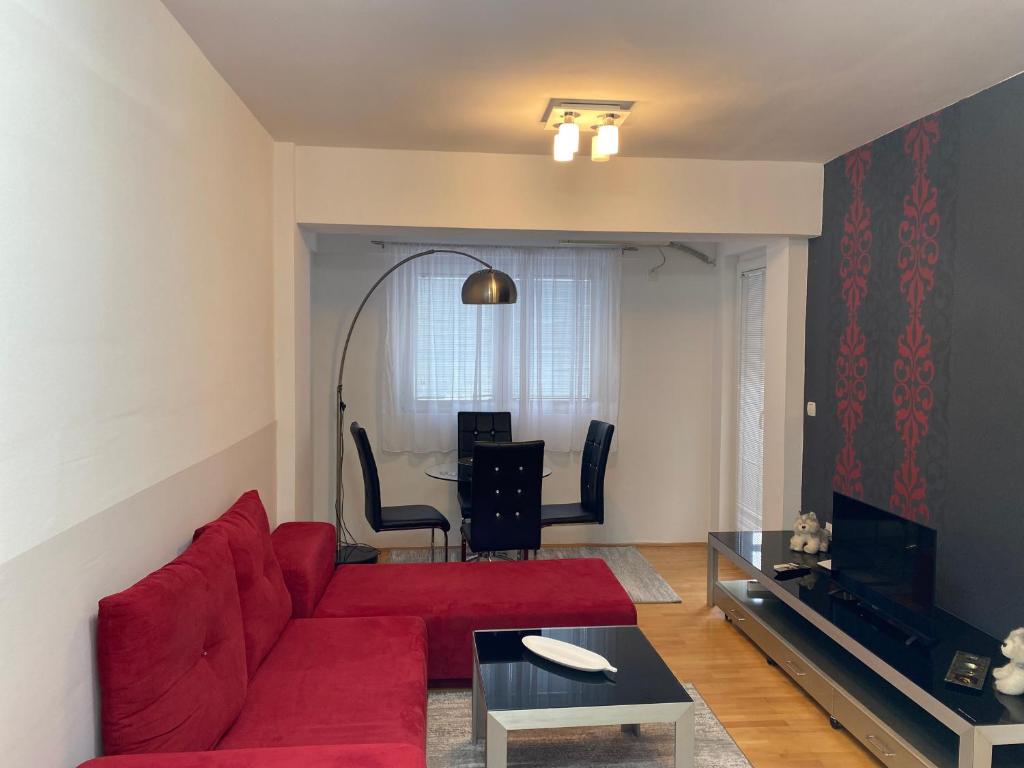 sala de estar con sofá rojo y mesa en Apartment Alex, en Ohrid