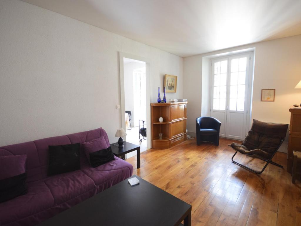 uma sala de estar com um sofá roxo e uma mesa em Appartement Évian-les-Bains, 2 pièces, 4 personnes - FR-1-498-14 em Évian-les-Bains