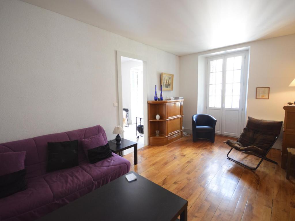 ein Wohnzimmer mit einem lila Sofa und einem Tisch in der Unterkunft Appartement charmant avec balcon, wifi et animaux admis à Évian-les-Bains - FR-1-498-14 in Évian-les-Bains