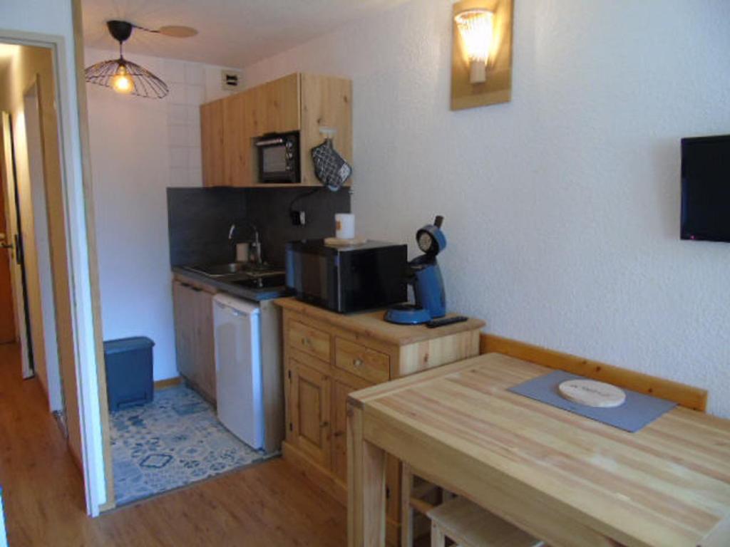 a small kitchen with a table and a microwave at Studio Valfréjus, 1 pièce, 3 personnes - FR-1-561-106 in Modane
