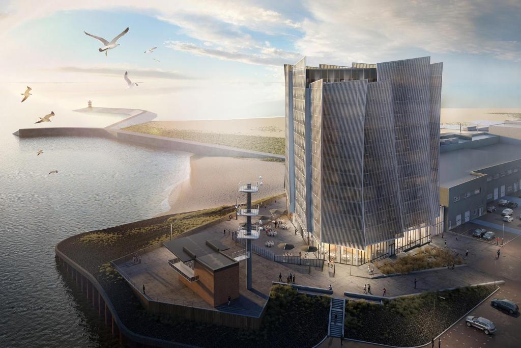 ein Bild eines hohen Gebäudes neben dem Wasser in der Unterkunft Inntel Hotels Den Haag Marina Beach in Scheveningen