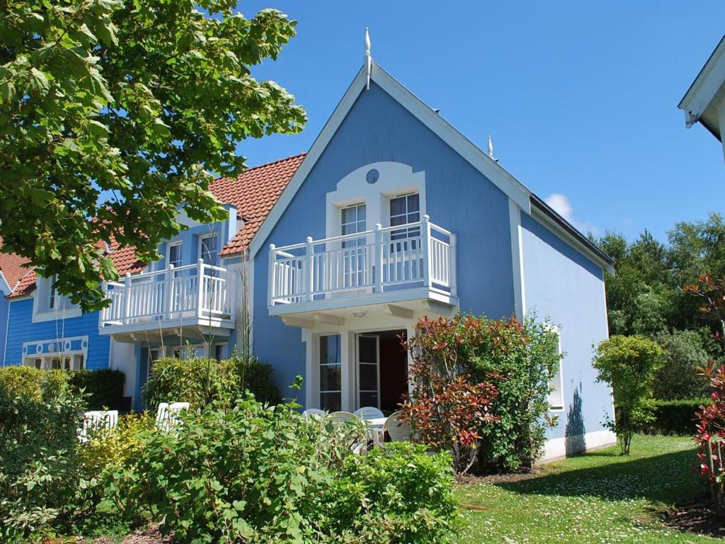 niebieski dom z białymi balkonami i krzakami w obiekcie Maison Fort-Mahon-Plage, 3 pièces, 4 personnes - FR-1-482-39 w mieście Fort-Mahon-Plage