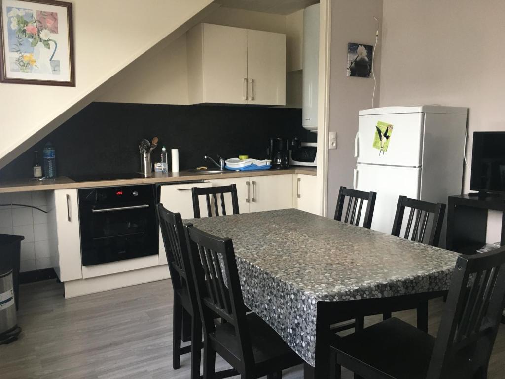 a kitchen with a table and chairs and a refrigerator at Appartement Fort-Mahon-Plage, 3 pièces, 6 personnes - FR-1-482-18 in Fort-Mahon-Plage