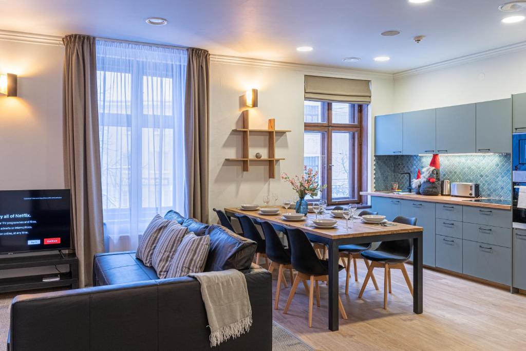 Il comprend une cuisine et un salon avec une table et un canapé. dans l'établissement Dandelion Apartments Bruņinieku, à Riga