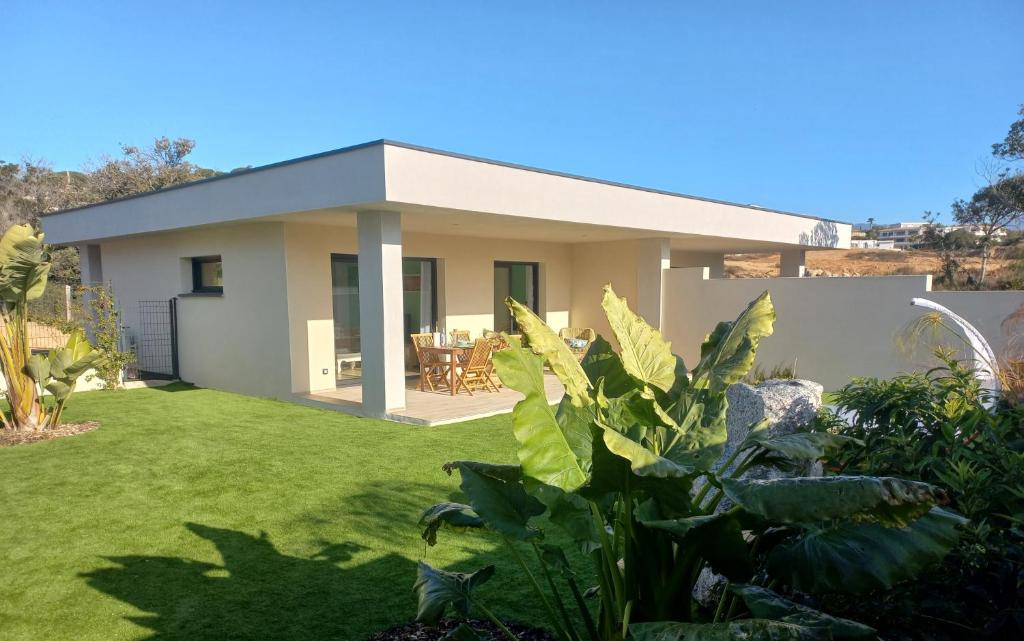 uma casa com um jardim verde com uma casa em Domaine de Pacciolello - Porticcio em Porticcio