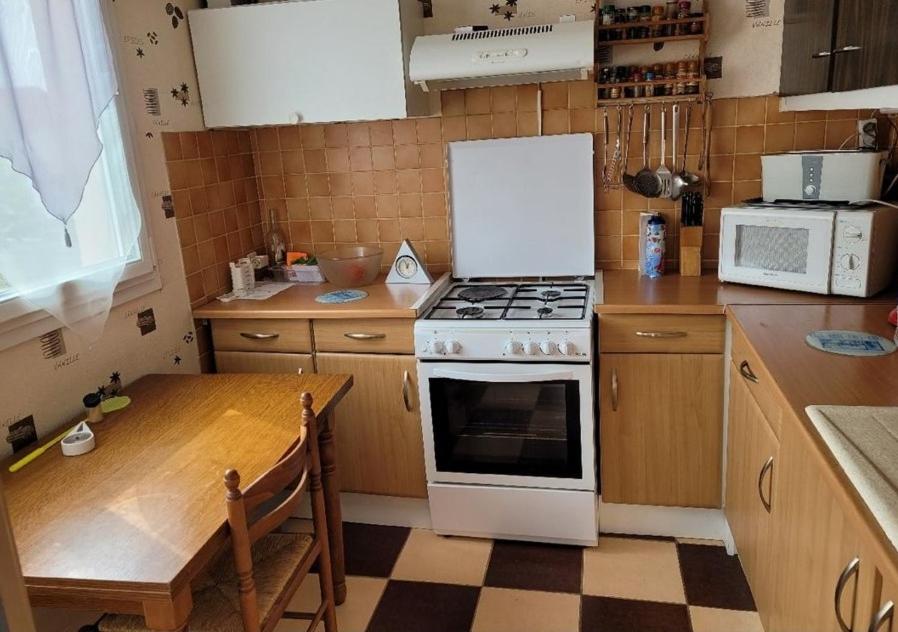 eine Küche mit einem Herd und einem Tisch darin in der Unterkunft Appartement f2 in Saint-Quentin