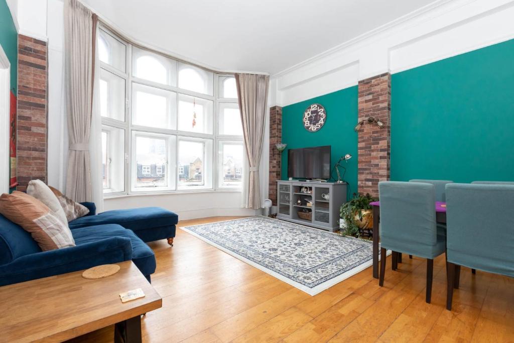 a living room with blue walls and a blue couch at Central 2 Bedroom Apartment near Old Street in London