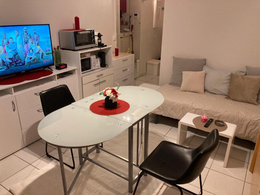 a living room with a white table and chairs at Studio calme et éclairé proche de Nation C in Paris